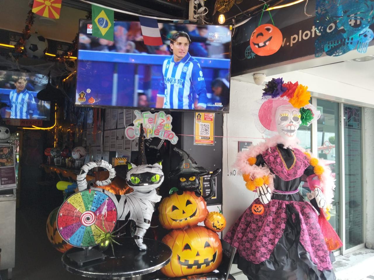 Vista panorámica decorada de Gorila Papas Sport Condesa con la Catrina, televisores de deportes y gato momificado