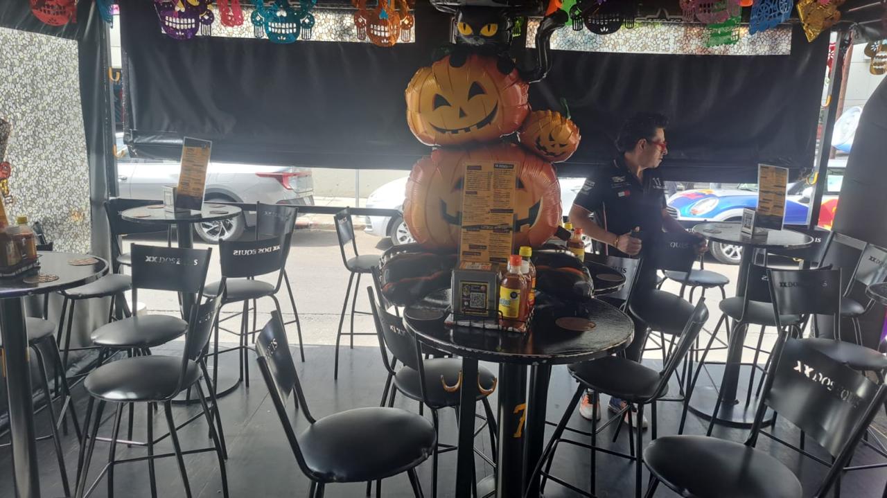 Mesas altas en terraza con centros de mesa de calabazas